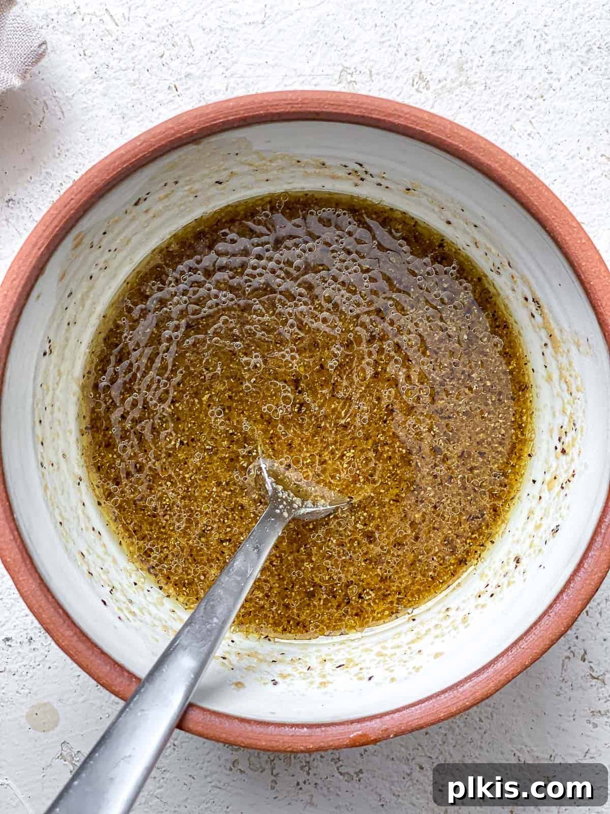 Roasted Pumpkin Harvest Salad 7 process shot showing dressing being mixed in a bowl