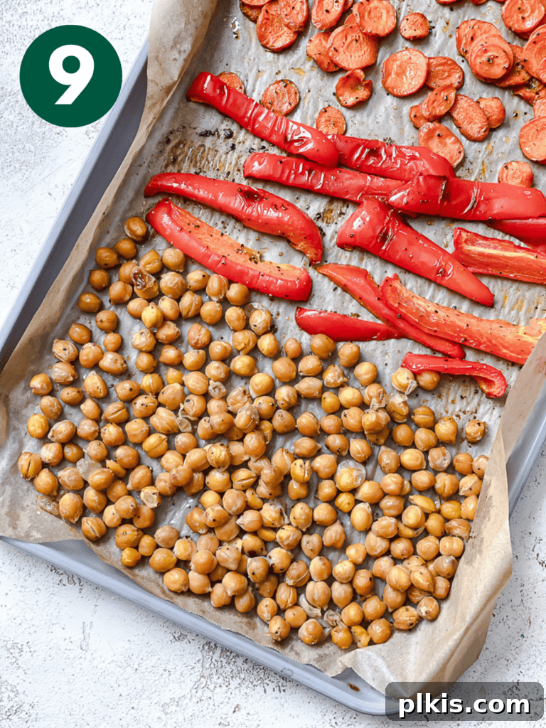 Roasted Sweet Potato Quinoa Power Bowl 12 Process shot of roasted chickpeas, bell peppers, and carrots on a baking dish, showing their tender and slightly caramelized texture.