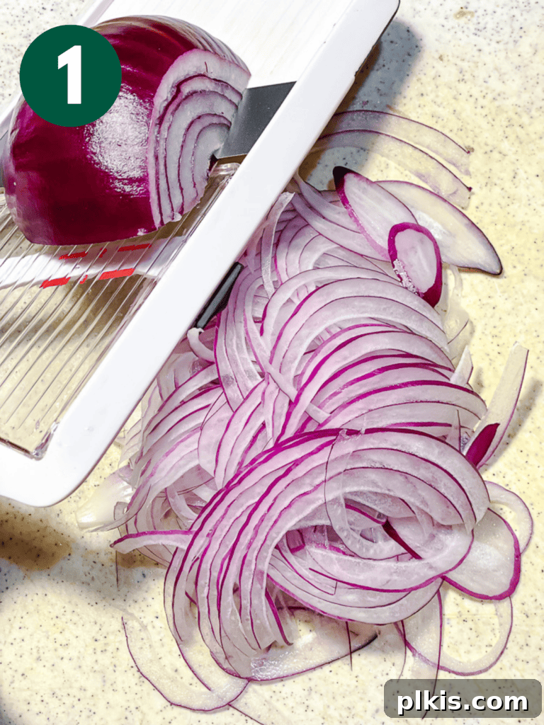 Roasted Sweet Potato Quinoa Power Bowl 4 Process shot of thinly slicing a red onion using a mandoline.