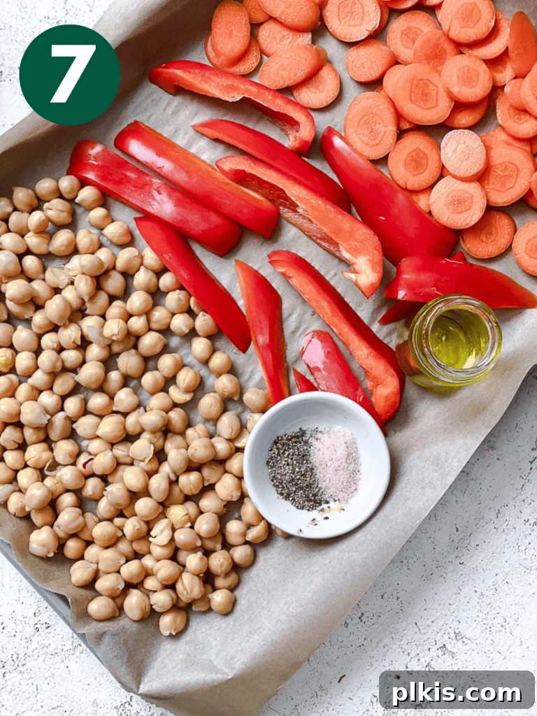 Roasted Sweet Potato Quinoa Power Bowl 10 Process shot showing chickpeas, bell pepper, and carrots arranged on a separate baking dish, seasoned and ready to roast.