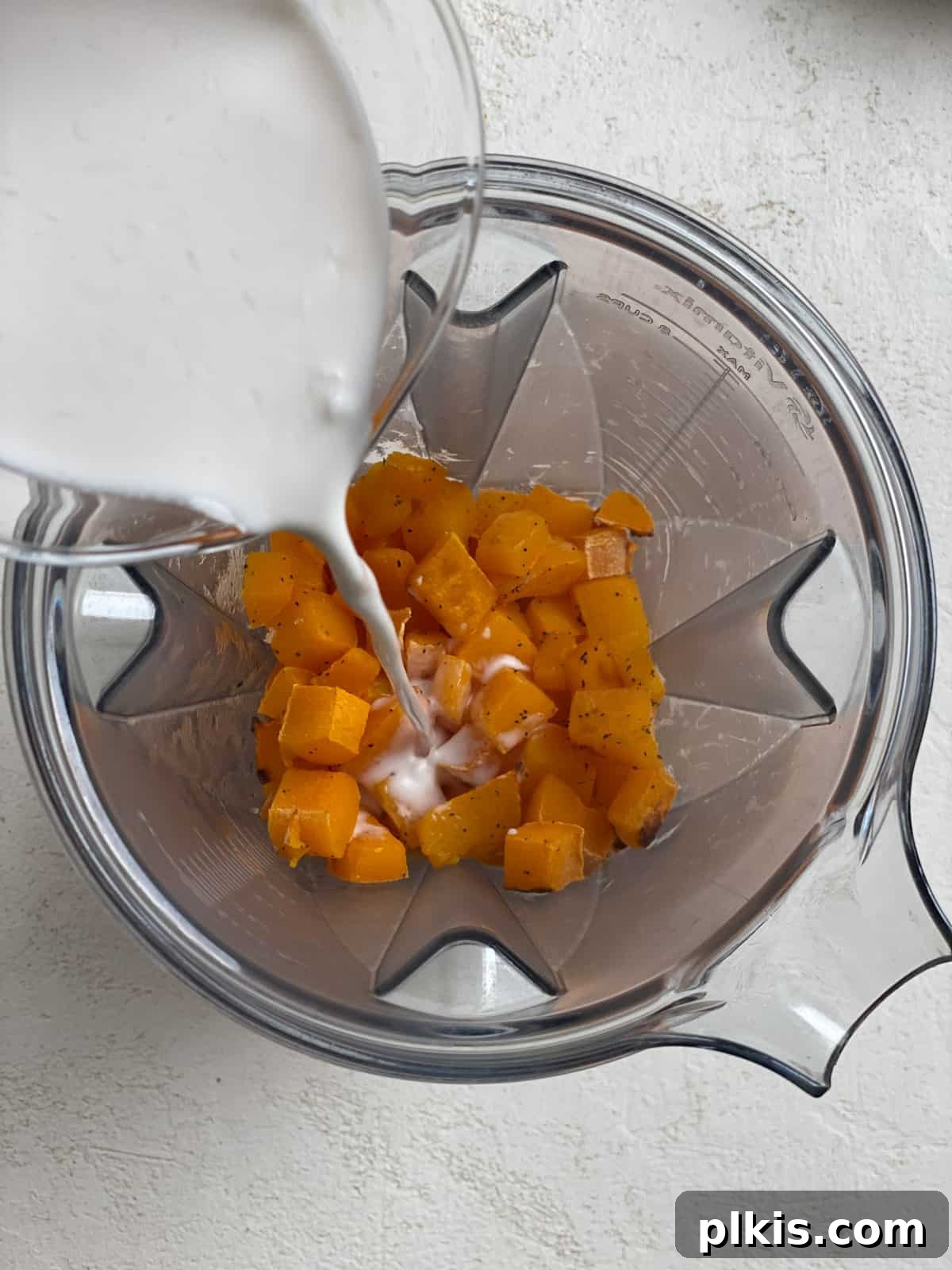 Creamy Vegan Pumpkin Dream 7 process shot of adding coconut milk to blender with roasted pumpkin