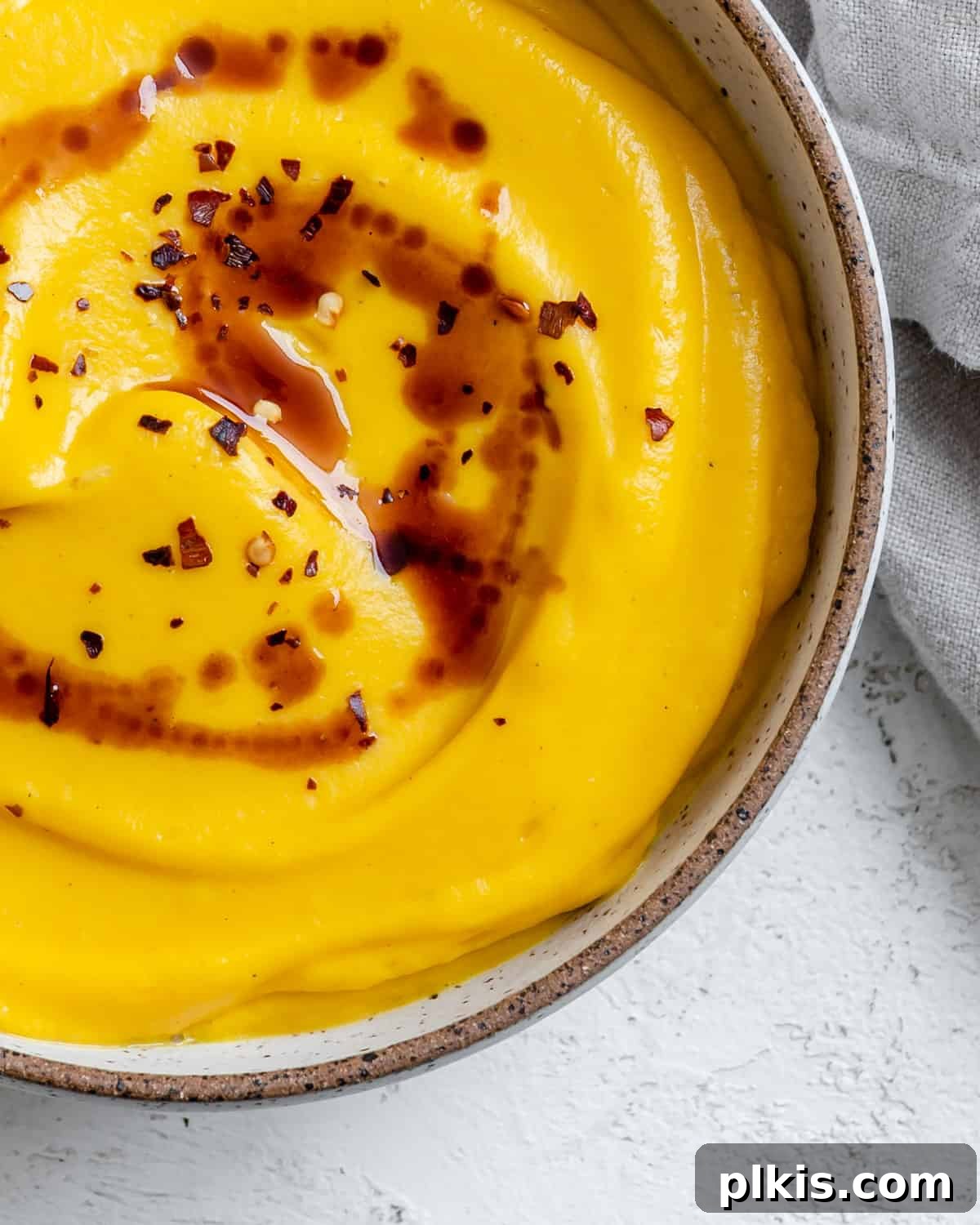 Creamy Vegan Pumpkin Dream 8 completed Easy Vegan Pumpkin Soup against a white surface, ready to be served