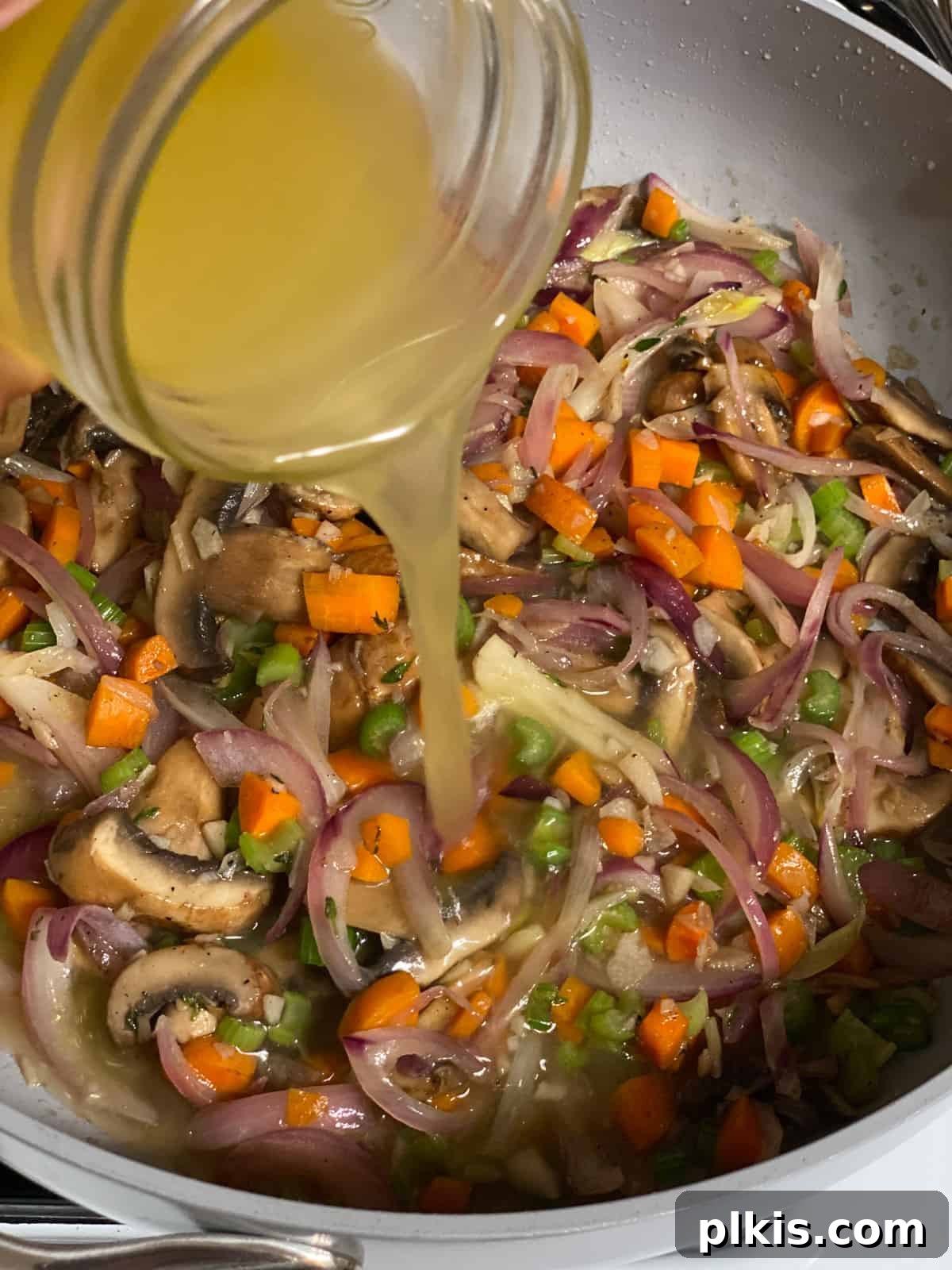 Simple & Savory Mushroom Stuffing 11 process of adding veggie broth to pan