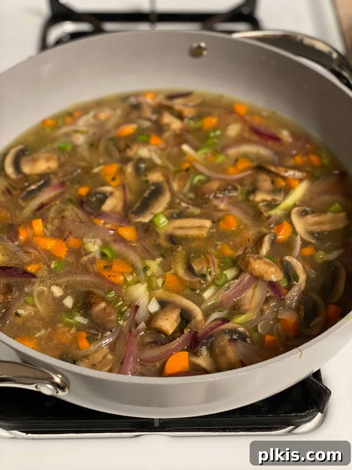 Simple & Savory Mushroom Stuffing 12 process of cooking veggies with broth in a pan