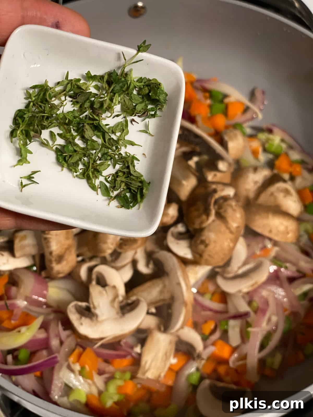 Simple & Savory Mushroom Stuffing 8 process of adding thyme to pan