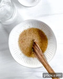 Peppermint Chocolate Chip Vegan Delights 4 A small white bowl containing flax meal and water, being mixed to form a flax egg, set against a bright white background.