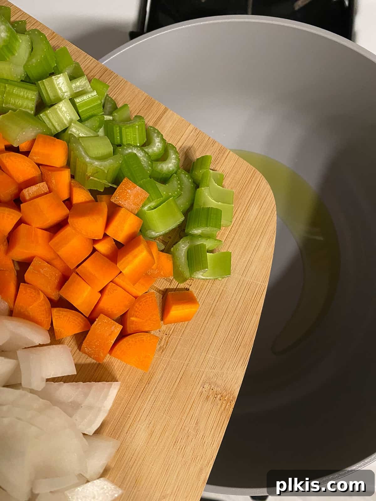 Golden Vegan Split Pea Goodness 4 Freshly chopped onions, garlic, carrots, and celery waiting on a wooden cutting board, ready for the soup pot.