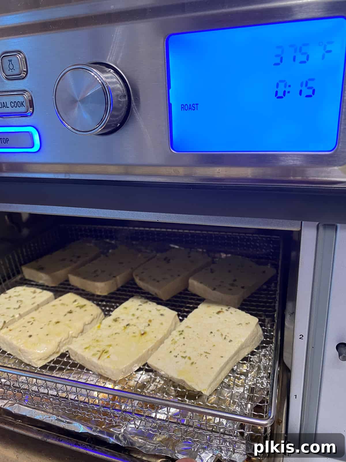 Pesto Tofu Sandwich: Simple Savory Superb 7 A baking sheet filled with seasoned tofu slices being carefully placed into a preheated oven to roast until golden and slightly firm.