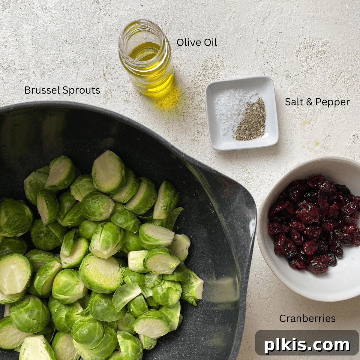 Tangy Cranberry Roasted Brussels Sprouts 3 Fresh Brussels sprouts, olive oil, salt, pepper, and dried cranberries laid out on a light surface.
