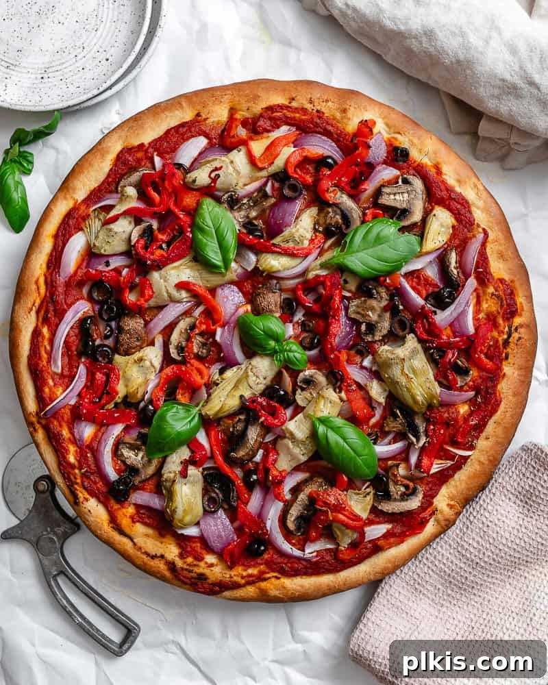 Simple Plant-Based Pizza Crust 2 Completed Easy Vegan Pizza Dough with vibrant pizza toppings on a white surface, ready to be enjoyed