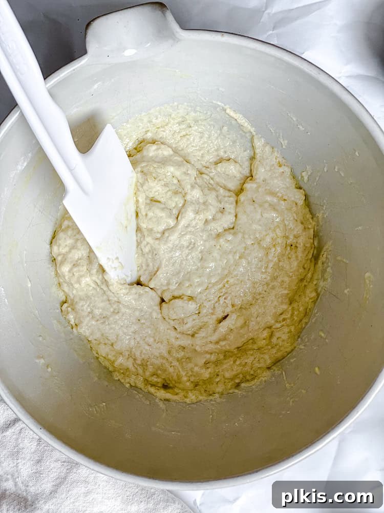 Simple Plant-Based Pizza Crust 5 Process shot showing wet ingredients being mixed into dry ingredients in a bowl for Easy Vegan Pizza Dough