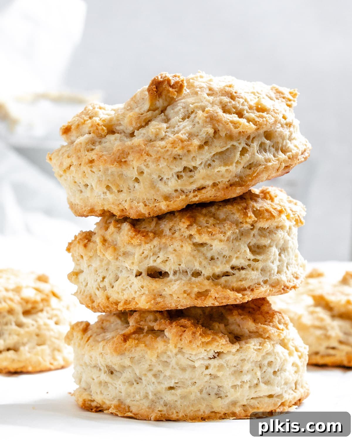 Effortless Plant-Based Biscuits in Minutes 2 Golden-brown, fluffy vegan buttermilk biscuits arranged on a white surface, ready to be served.