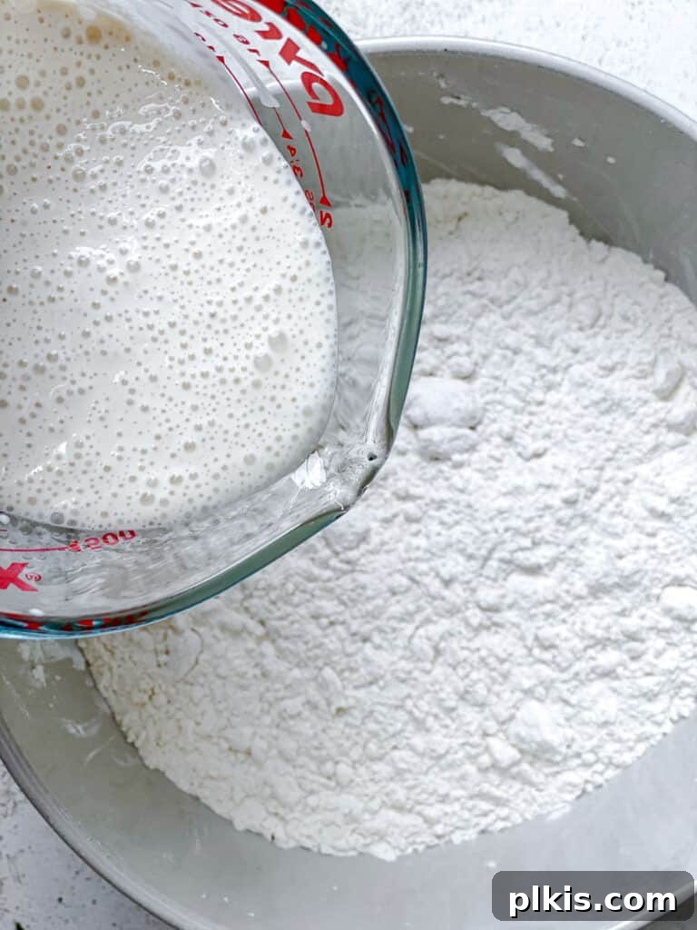 Effortless Plant-Based Biscuits in Minutes 9 The prepared vegan buttermilk mixture is poured into the bowl of dry ingredients.