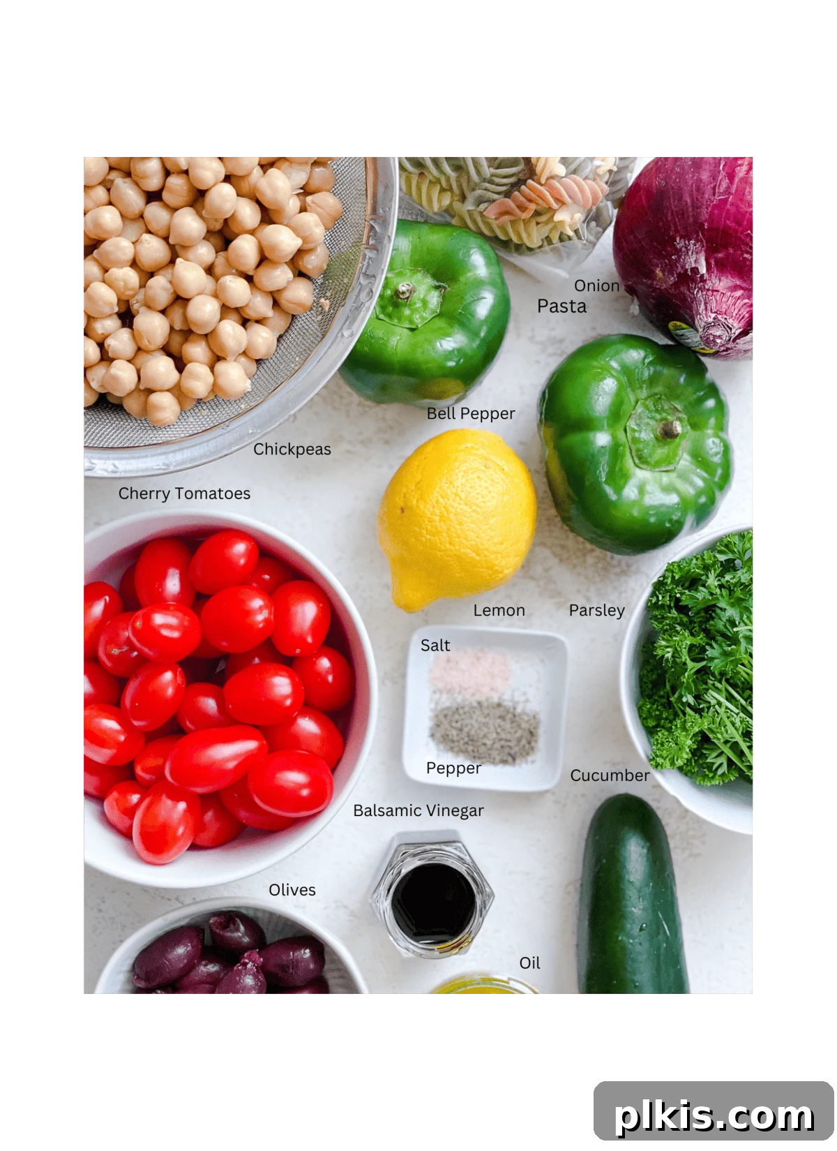 Carefully measured ingredients for Mediterranean Vegan Pasta Salad, neatly arranged on a white surface, ready for preparation.