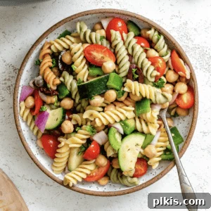 Completed Mediterranean Vegan Pasta Salad plated against a white surface, showcasing the freshness and appeal of the dish.