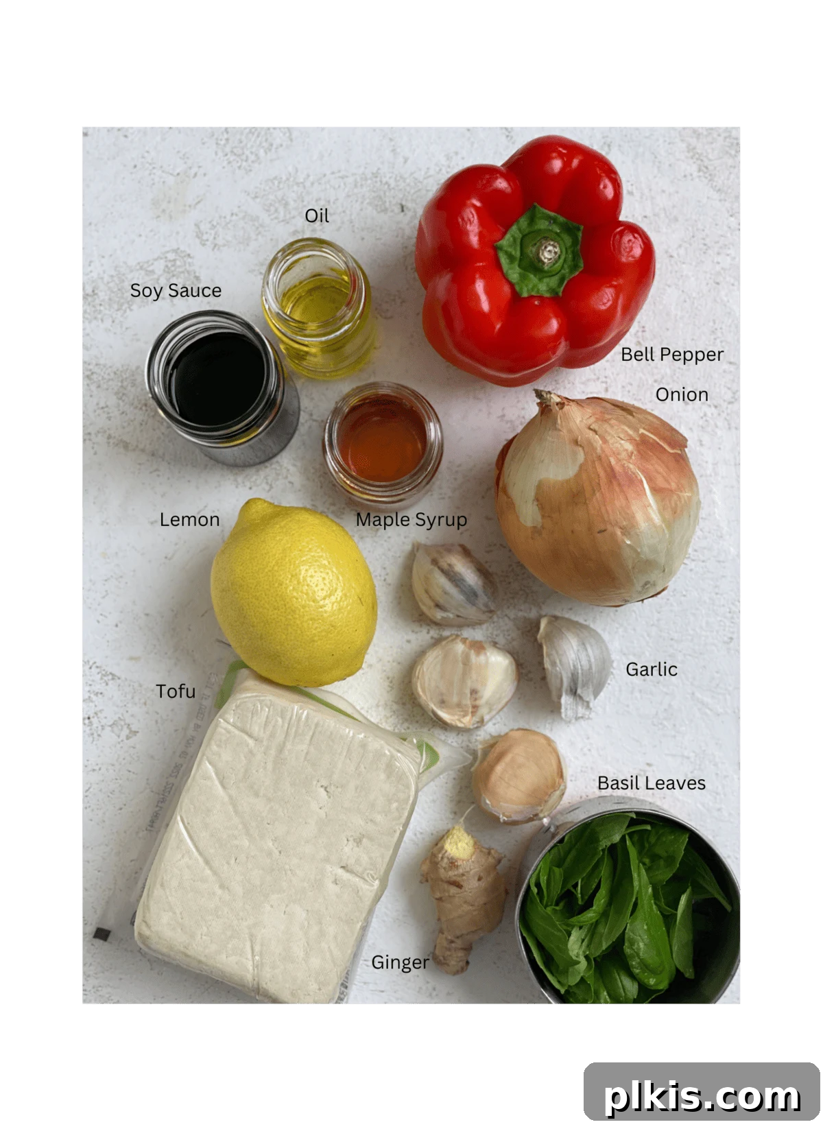 Vibrant Lemon Basil Tofu 3 All the fresh ingredients laid out for Lemon Basil Tofu on a white surface, including tofu, basil, lemon, onion, bell pepper, and sauce components.