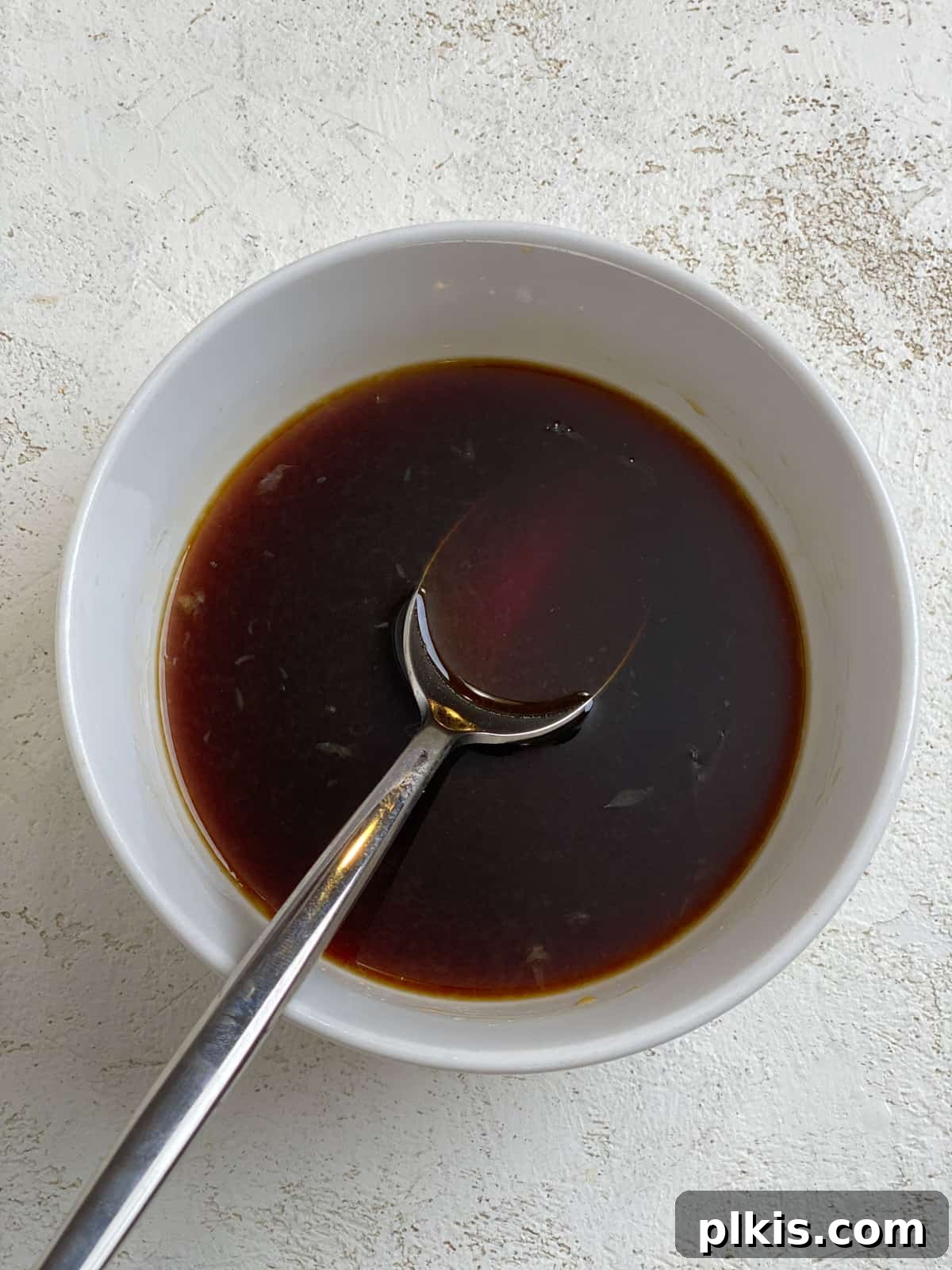 Vibrant Lemon Basil Tofu 5 A small white bowl containing the mixed soy sauce, lemon juice, and maple syrup marinade.