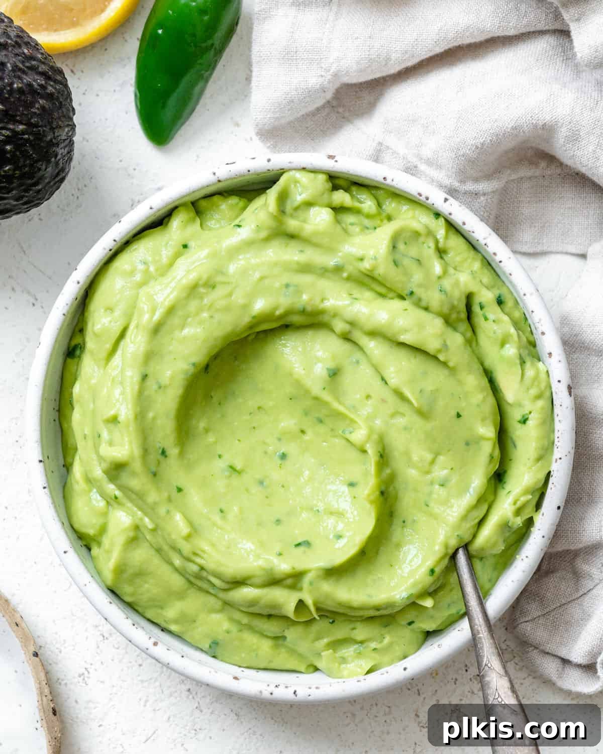 Instant Mexican Avocado Crema 2 Completed Mexican Avocado Crema in a white bowl against a white background, garnished with cilantro