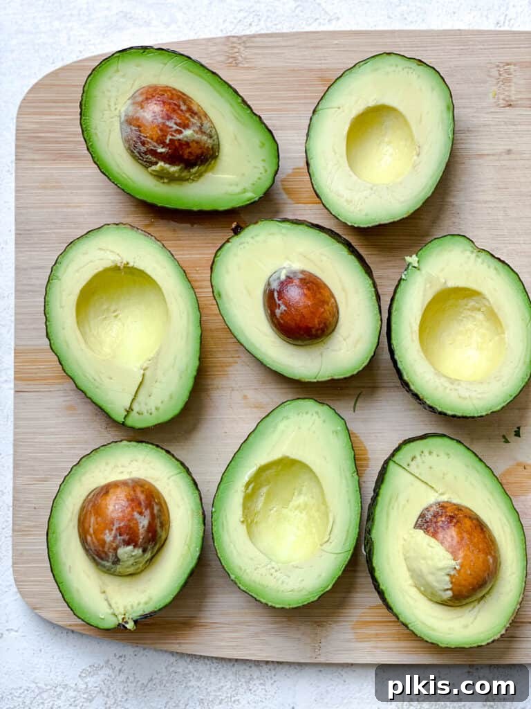 Instant Mexican Avocado Crema 4 Halved avocados against a cutting board, ready for use