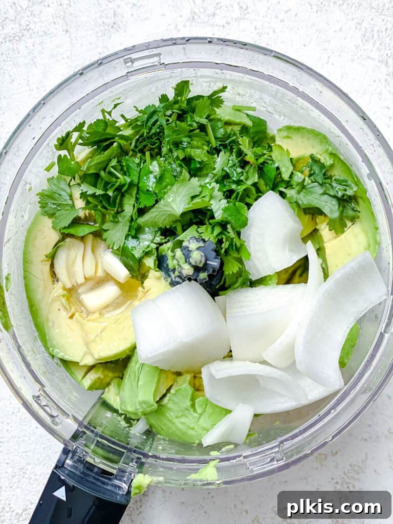 Instant Mexican Avocado Crema 5 Process shot of adding ingredients into a food processor for avocado crema