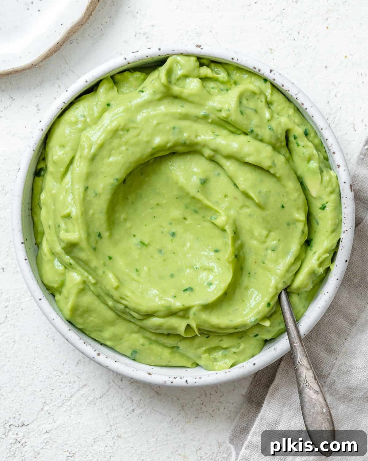 Instant Mexican Avocado Crema 7 Completed Mexican Avocado Crema in a white bowl against a white background, ready to serve