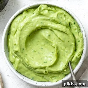 Instant Mexican Avocado Crema 8 Completed Mexican Avocado Crema in a white bowl against a white background