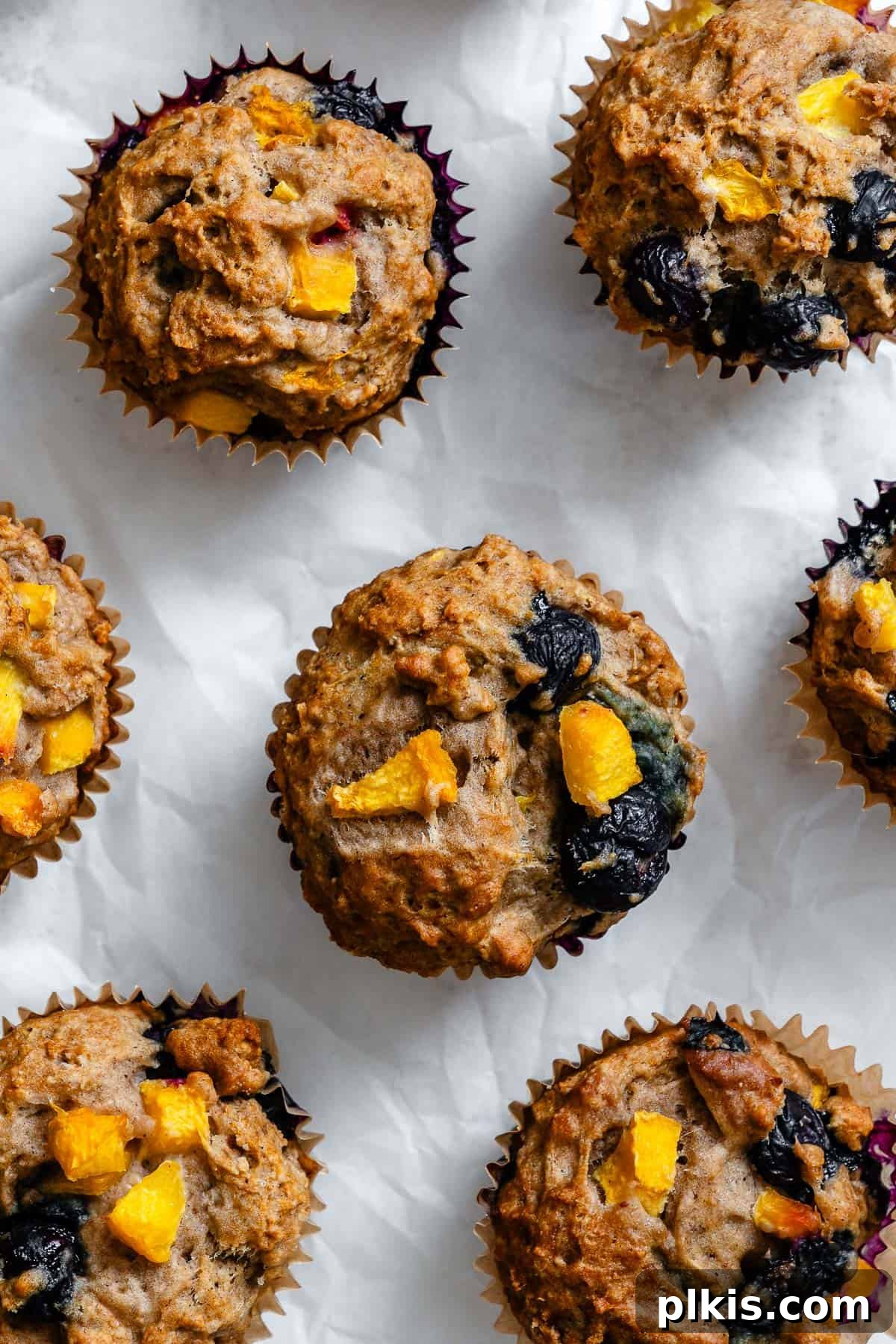 Bursting Blueberry Peach Delights 2 completed Blueberry Peach Muffins on white surface