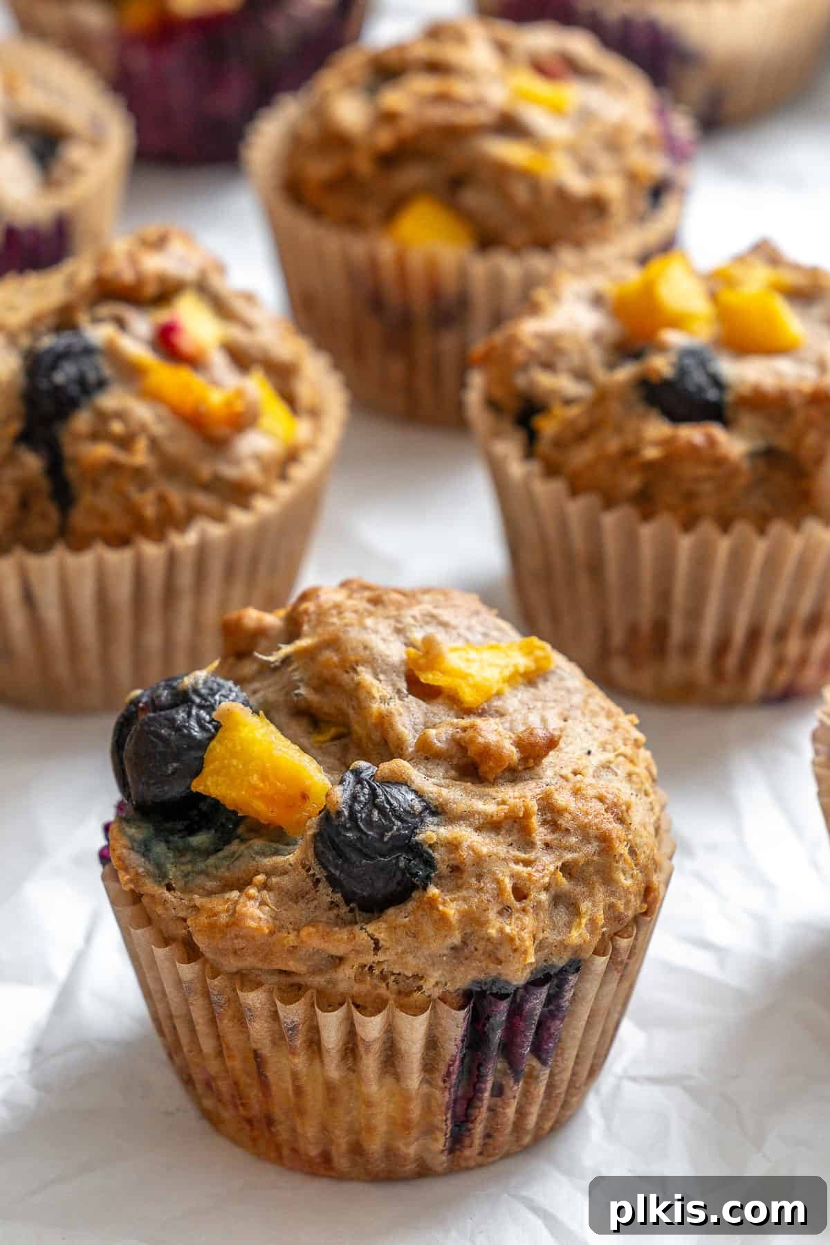 Bursting Blueberry Peach Delights 8 completed Blueberry Peach Muffins on white surface