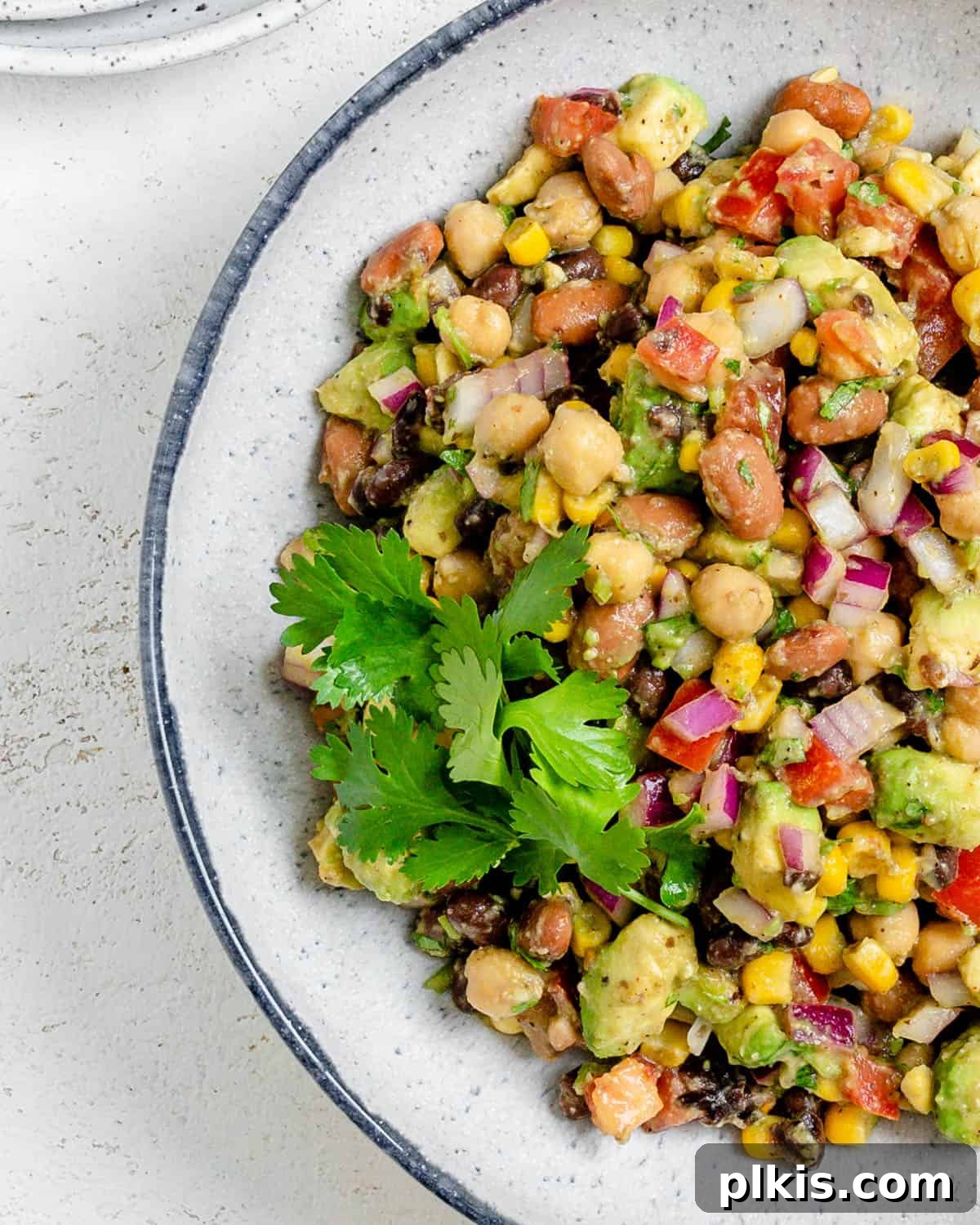 completed Texas Caviar [Avocado Corn and Bean Salad] in a white plate against a light background