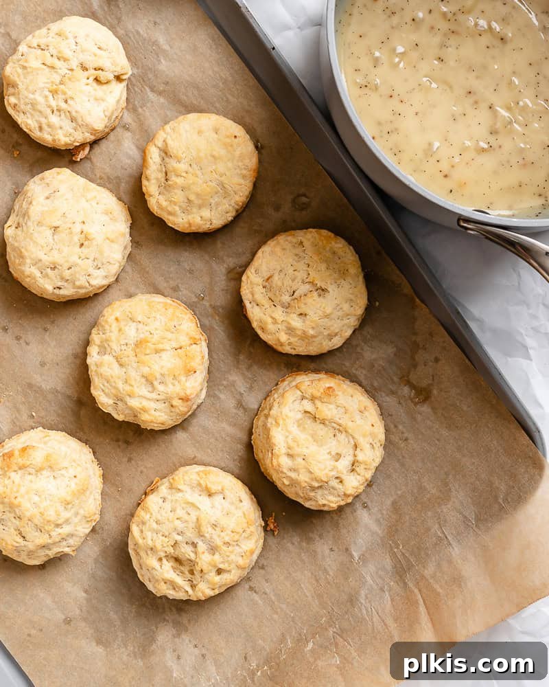 Southern Comfort Reimagined Vegan 13 Process shot showing vegan gravy being ladled next to freshly baked biscuits on a baking tray.