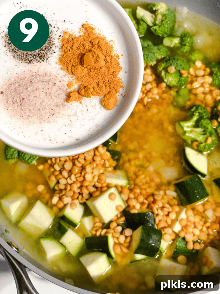 Golden Turmeric Veggie Split Pea Stew 12 Spices, including turmeric, being stirred into the pot for a flavor boost.