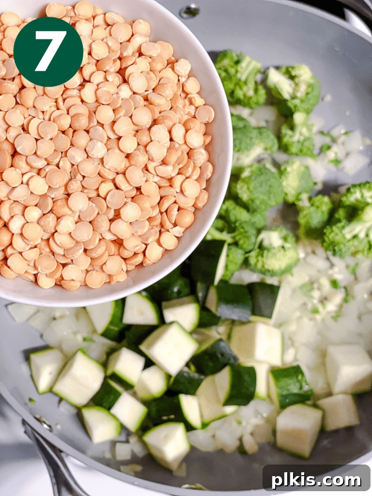 Golden Turmeric Veggie Split Pea Stew 10 Yellow split peas being added to the pan, ready to absorb flavors and soften.