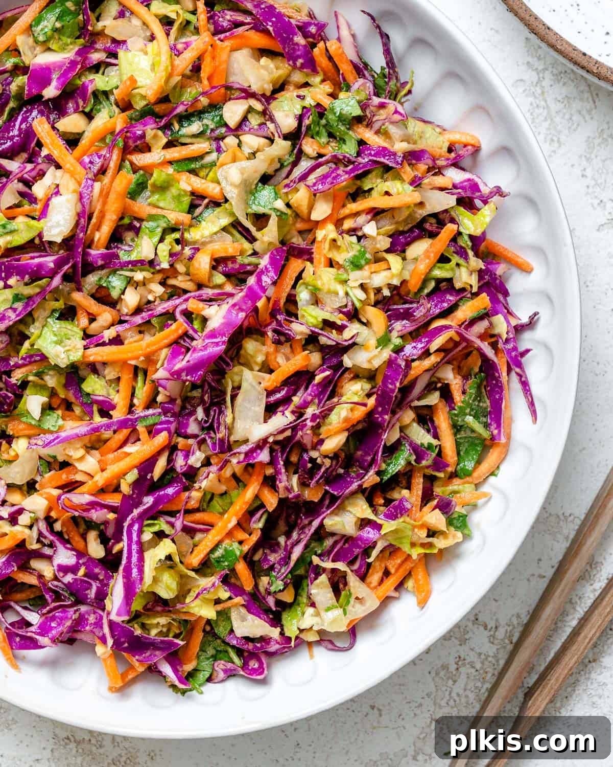 Zesty Thai Peanut Salad 6 A stunning final presentation of Crunchy Thai Peanut Salad in a pristine white bowl, showcasing its colorful ingredients and creamy dressing, ready to be enjoyed.