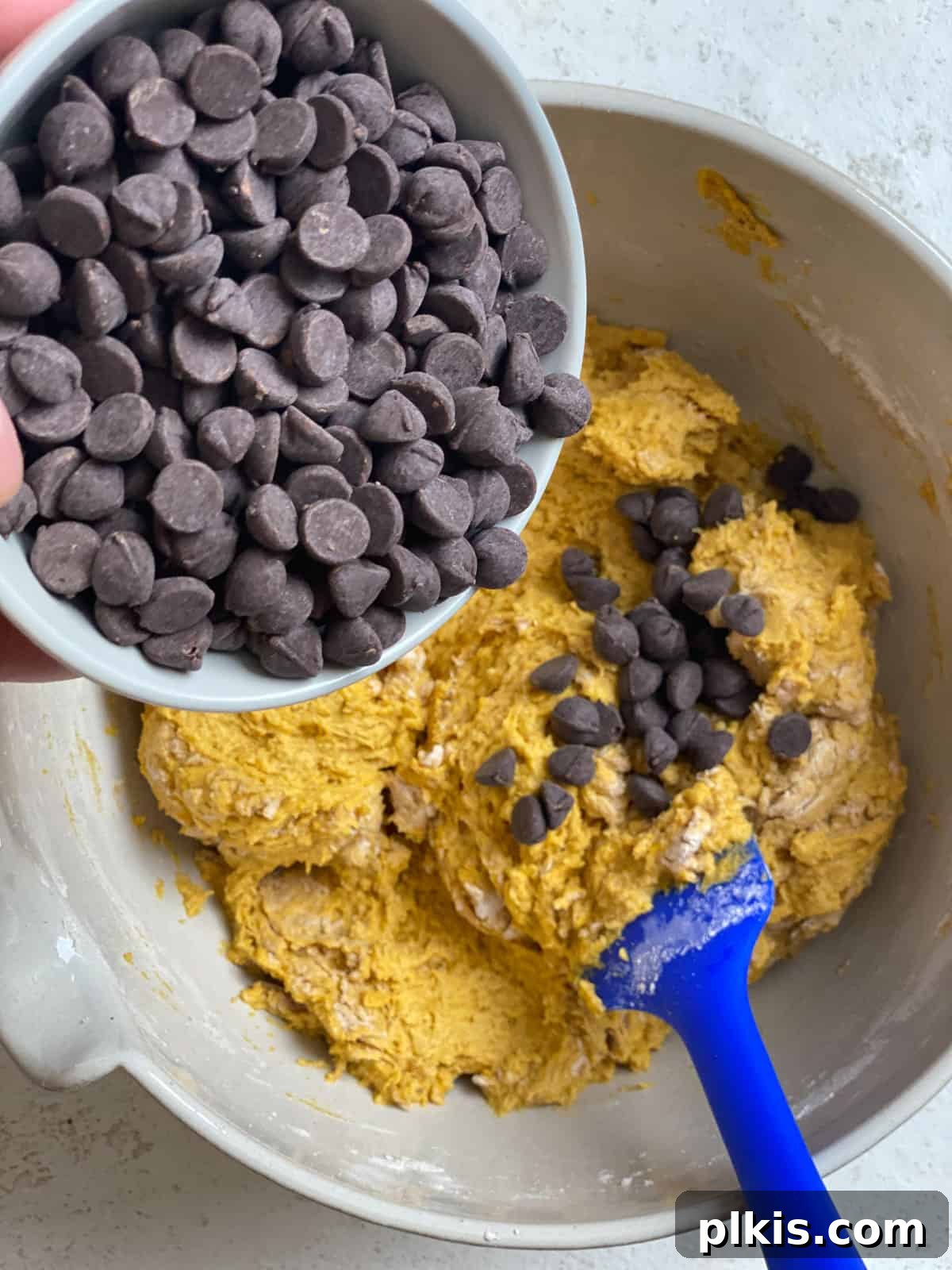 Spiced Vegan Pumpkin Chocolate Chip Muffins 11 process of adding vegan chocolate chips to pumpkin mixture