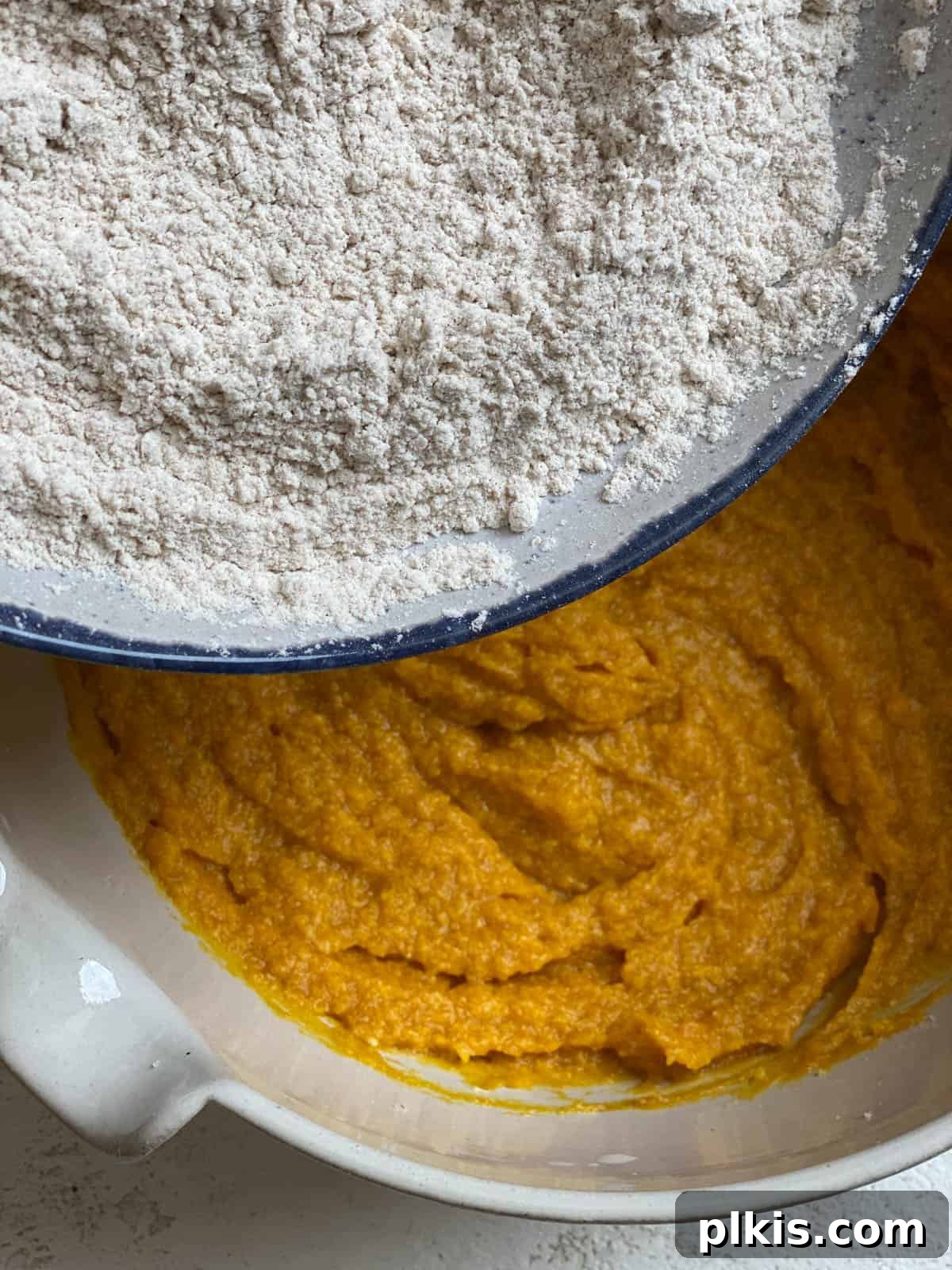 Spiced Vegan Pumpkin Chocolate Chip Muffins 10 process of adding flour to pumpkin mixture