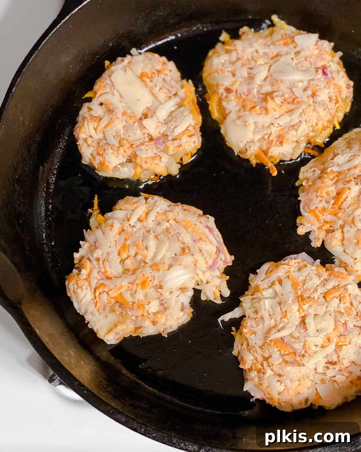 Golden Sweet Potato Latkes 7 Process shot showing Sweet Potato Latkes cooking in a pan