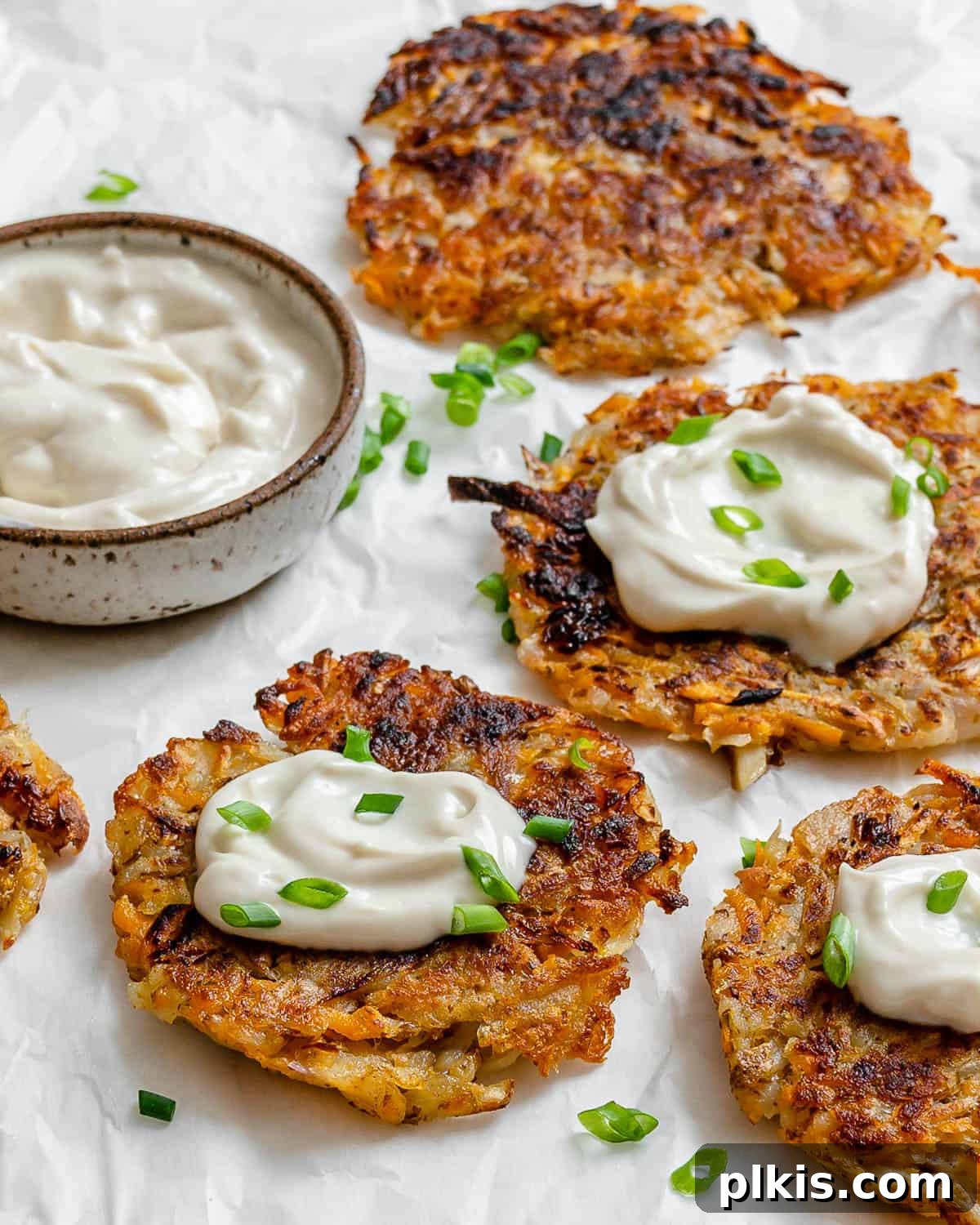 Golden Sweet Potato Latkes 8 Several completed Sweet Potato Latkes on a white surface, ready to be served