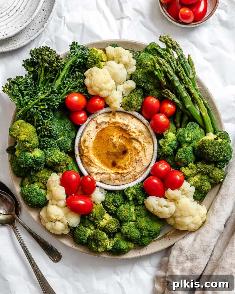 Christmas Tree Veggie Tray 2 Beautifully arranged Christmas Veggie Tray shaped like a tree or wreath, served on a white platter.