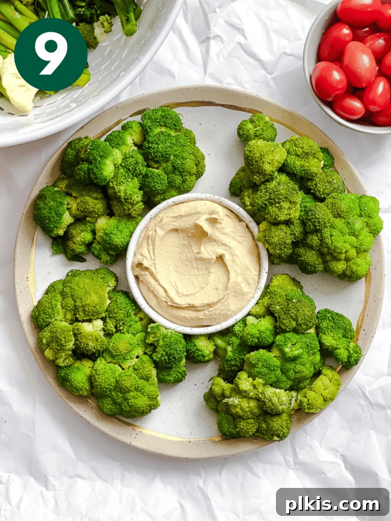 Christmas Tree Veggie Tray 12 Arranging broccoli florets around the dip bowl to form the base of the veggie wreath.