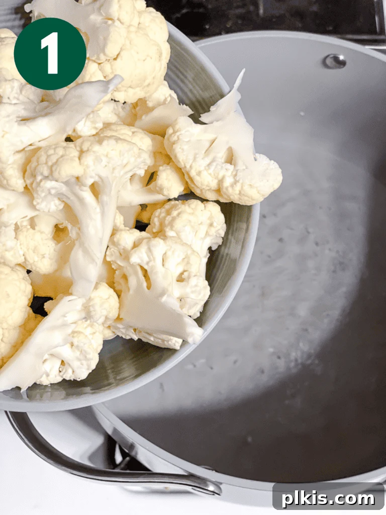 Christmas Tree Veggie Tray 4 Step-by-step image of adding cauliflower to a pot for steaming.