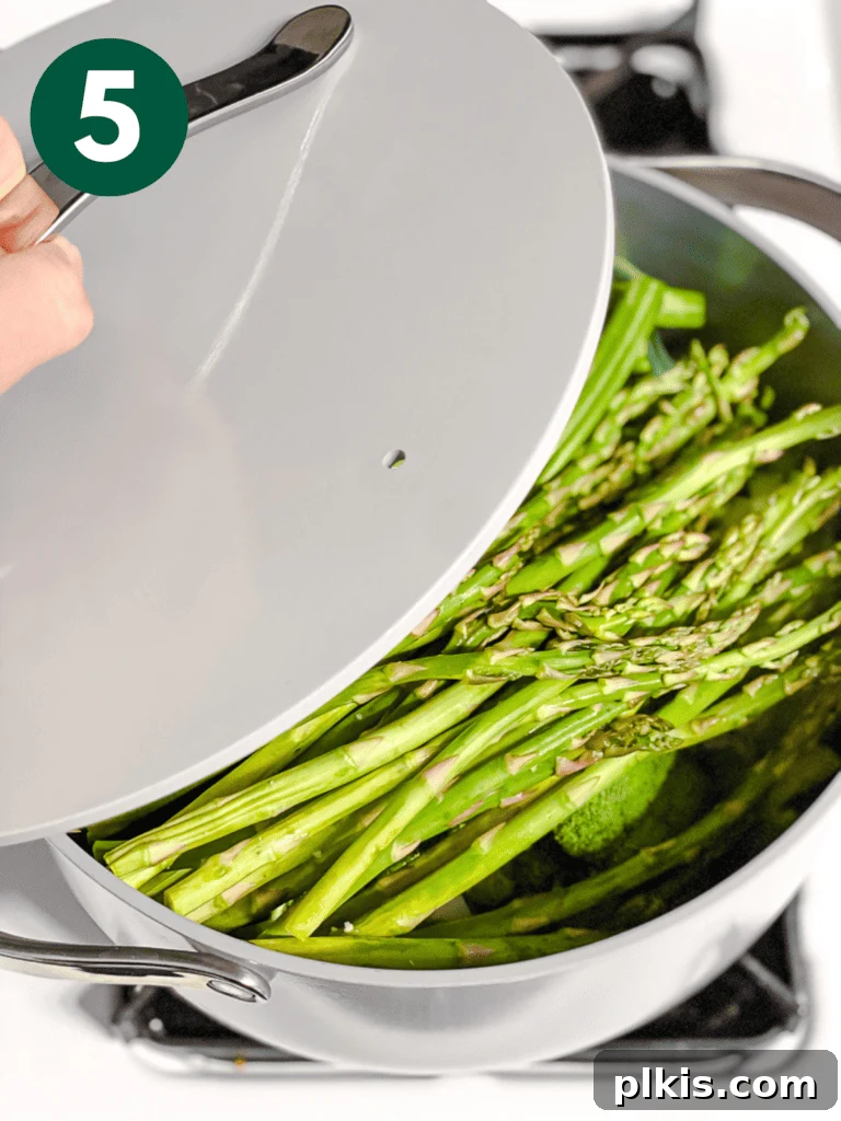 Christmas Tree Veggie Tray 8 Step-by-step image of covering a pot with a lid to steam vegetables.