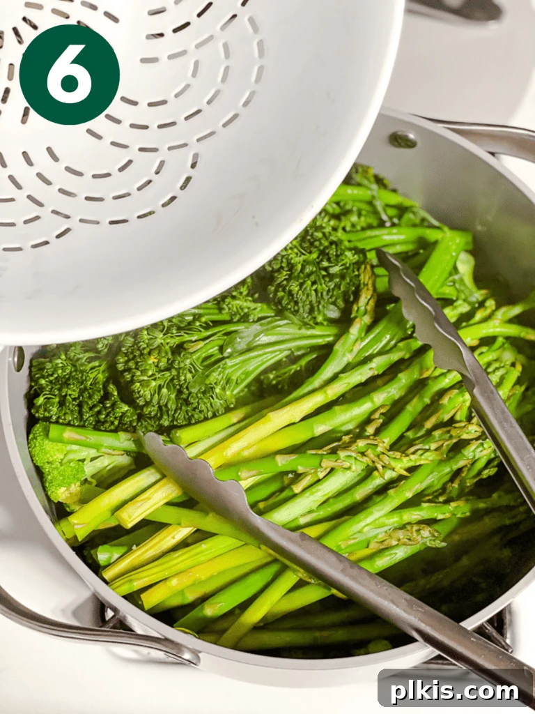 Christmas Tree Veggie Tray 9 Step-by-step image of transferring steamed vegetables to a colander.