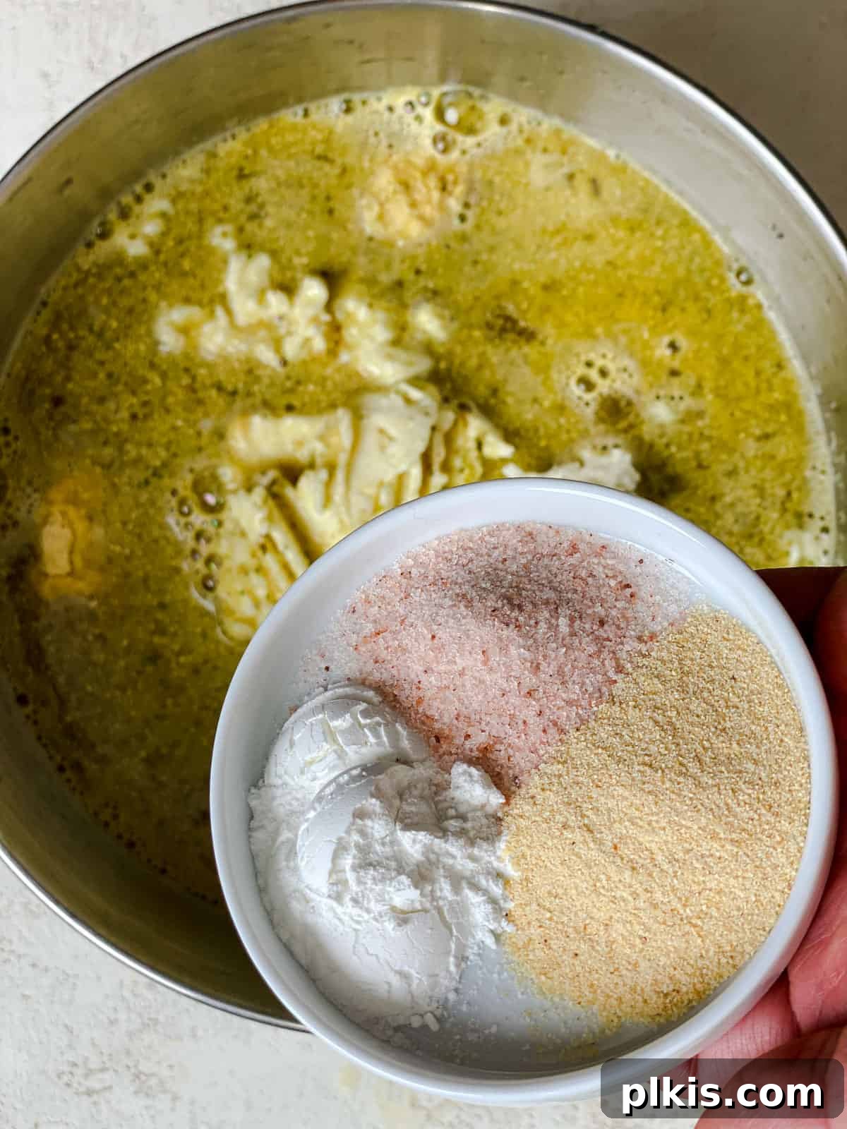Crafting Perfect Vegan Tamales 7 Process shot of adding spices like garlic powder to the masa mixture.