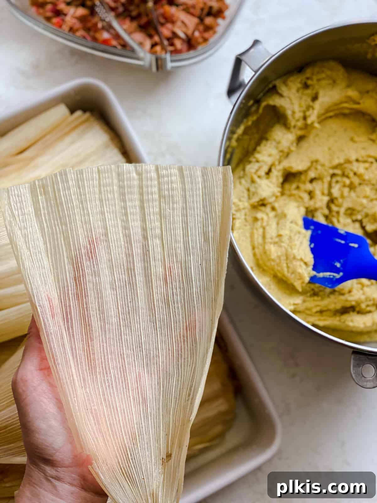 Crafting Perfect Vegan Tamales 10 Process shot showing a corn husk being prepared for filling, laid flat.