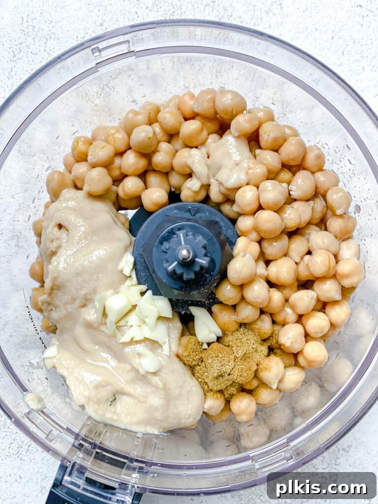 Quick & Creamy Hummus 5 Close-up process shot of adding all the hummus ingredients into a food processor for blending.