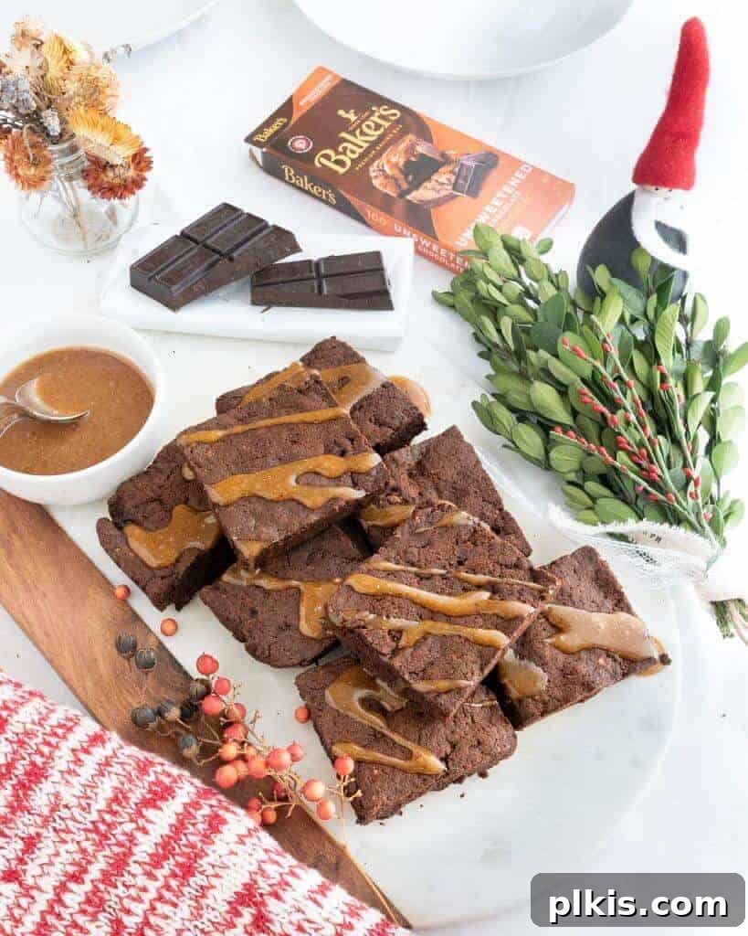 Salted Caramel Fudge Brownies 2 Caramel drizzled brownies on a white marble board.
