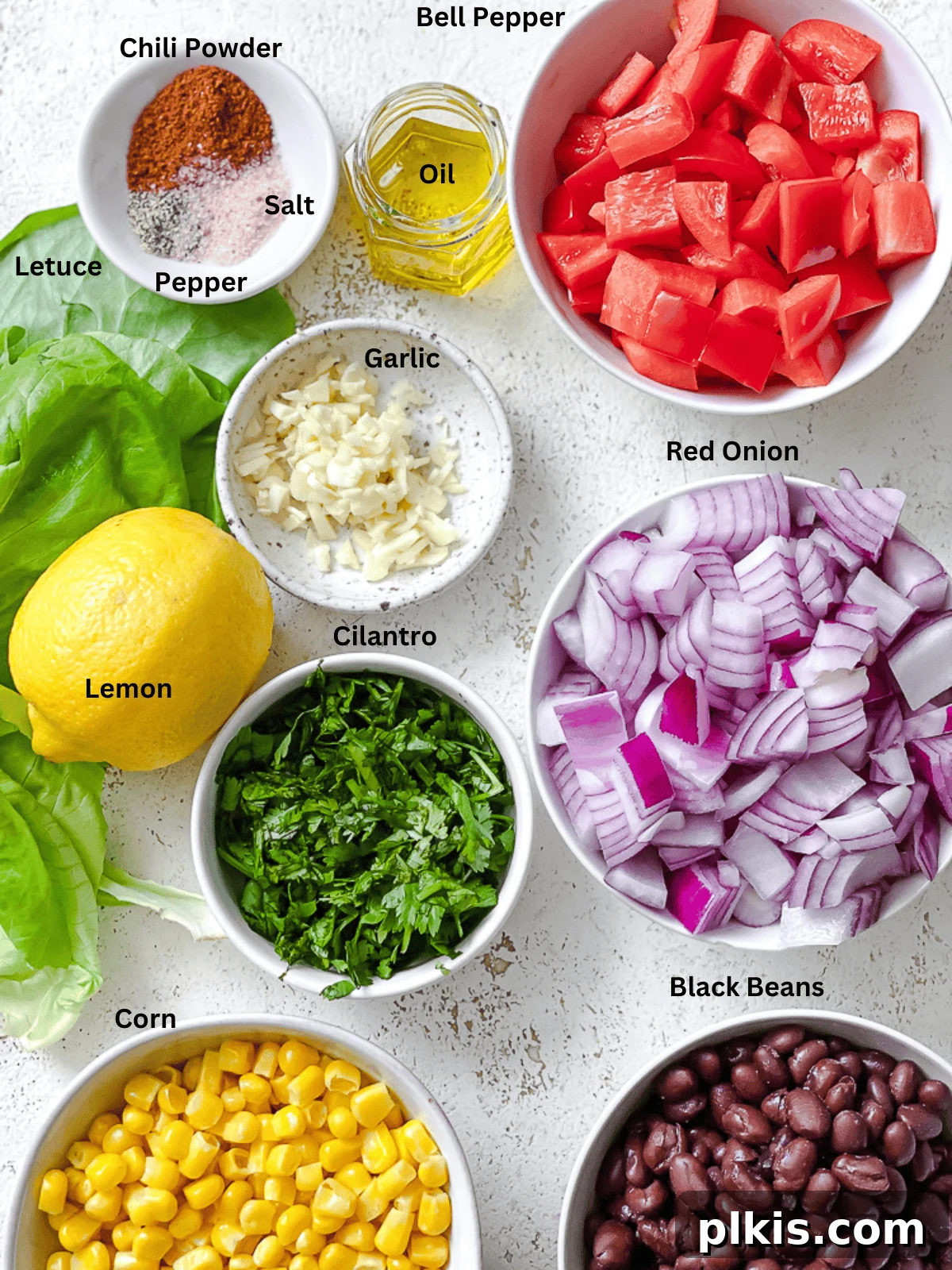 Zesty Bean and Corn Lettuce Wraps 3 A curated selection of fresh ingredients for Vegetarian Lettuce Wraps, including black beans, corn, bell pepper, onion, garlic, and cilantro, neatly arranged on a white surface.