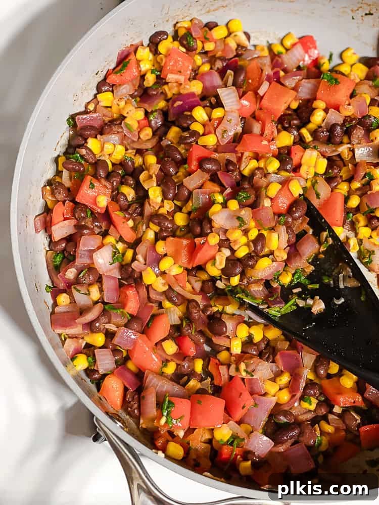 Zesty Bean and Corn Lettuce Wraps 6 Close-up process shot of the vibrant black bean and corn filling, perfectly seasoned and mixed, being stirred in a pan, ready for assembly into lettuce wraps.