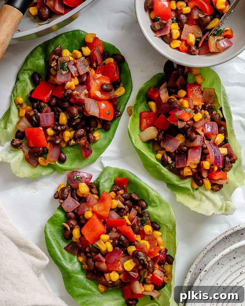 Zesty Bean and Corn Lettuce Wraps 7 A selection of perfectly prepared Vegetarian Lettuce Wraps (Beans & Corn) elegantly presented on a white serving platter, ready to be enjoyed.