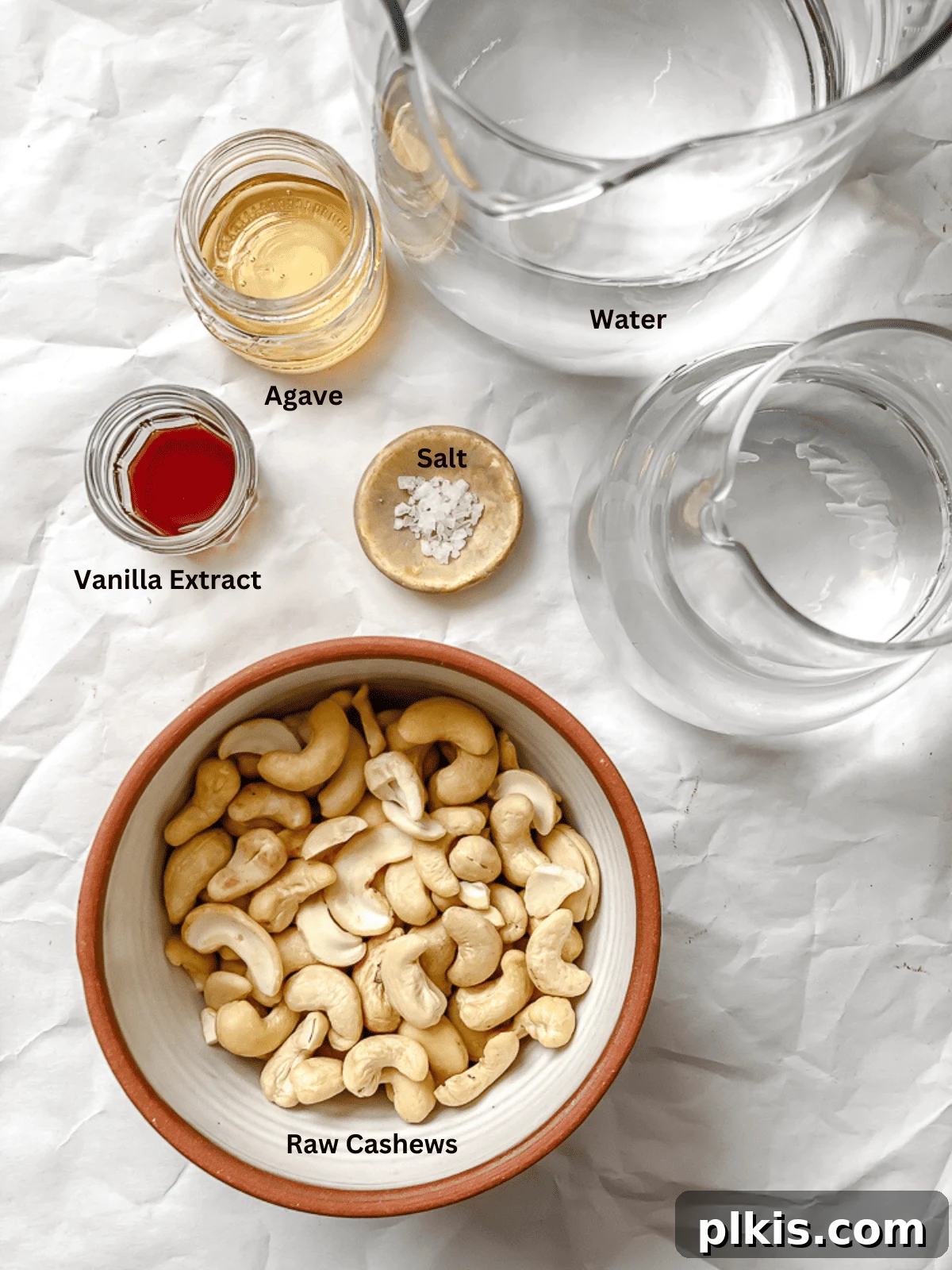 Whip Up Your Own Cashew Milk 3 ingredients for cashew Milk measured out, including raw cashews, water, maple syrup, and vanilla